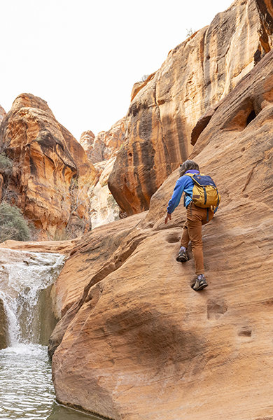 A woman hiking a slot canyon in the desert