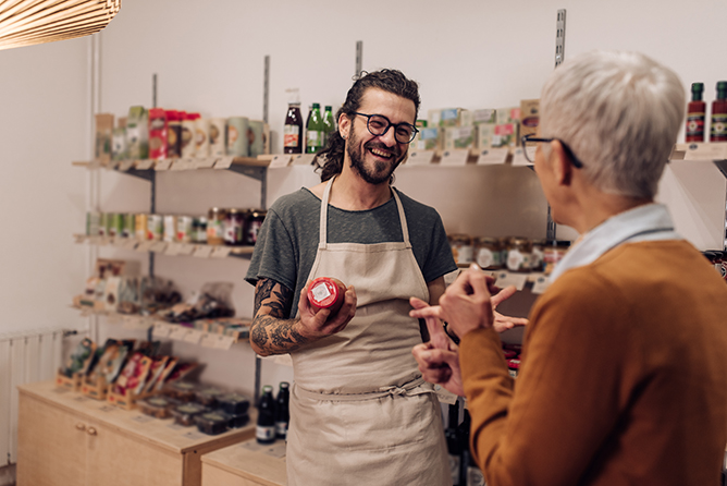 Charming young salesman recommending the product to his customer