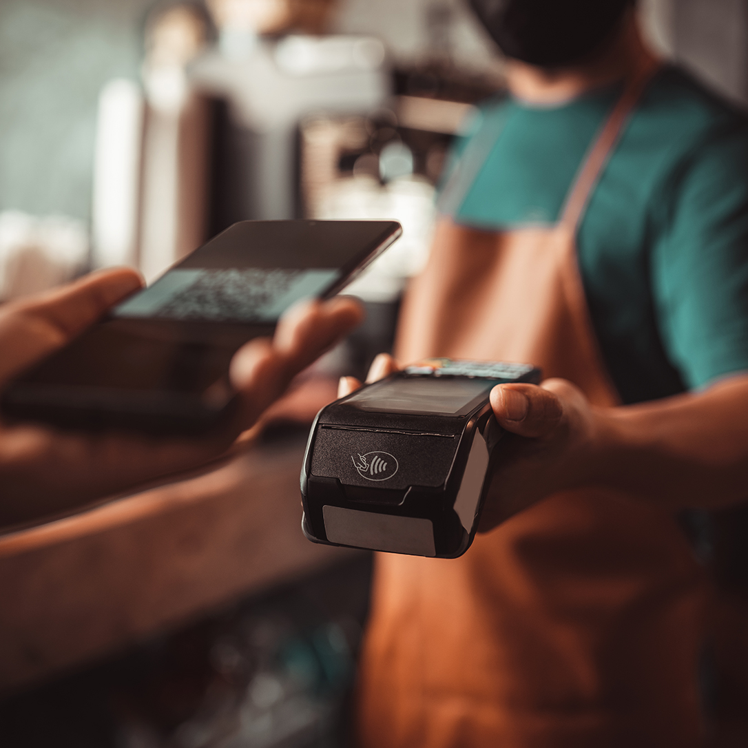Smartphone QR code payment with credit card reader machine at the cafe