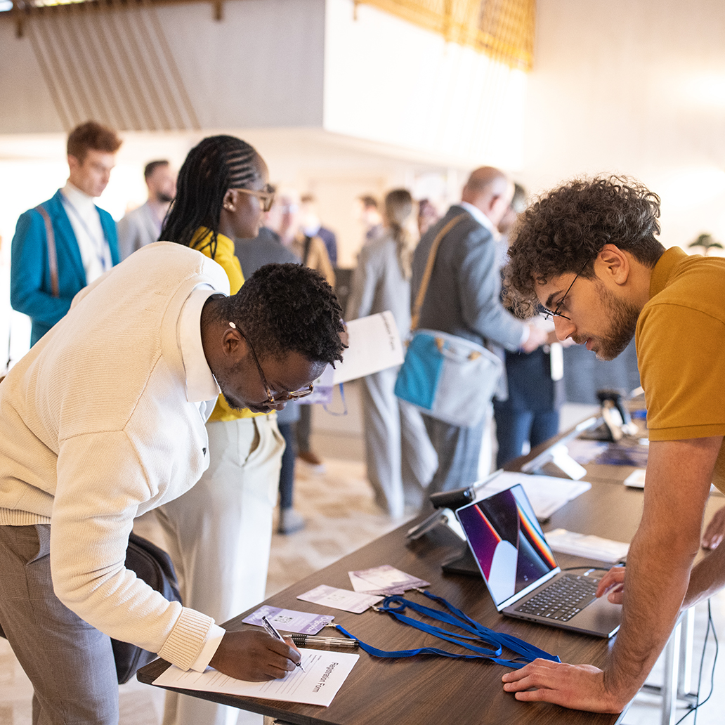 Business conference participants registering for a conference in the lobby of a luxury hotel