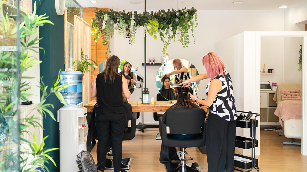 Unifying a Digital Ecosystem to Strengthen Artist Retention 1 Hairdressers making curls at a client's hair with curling irons