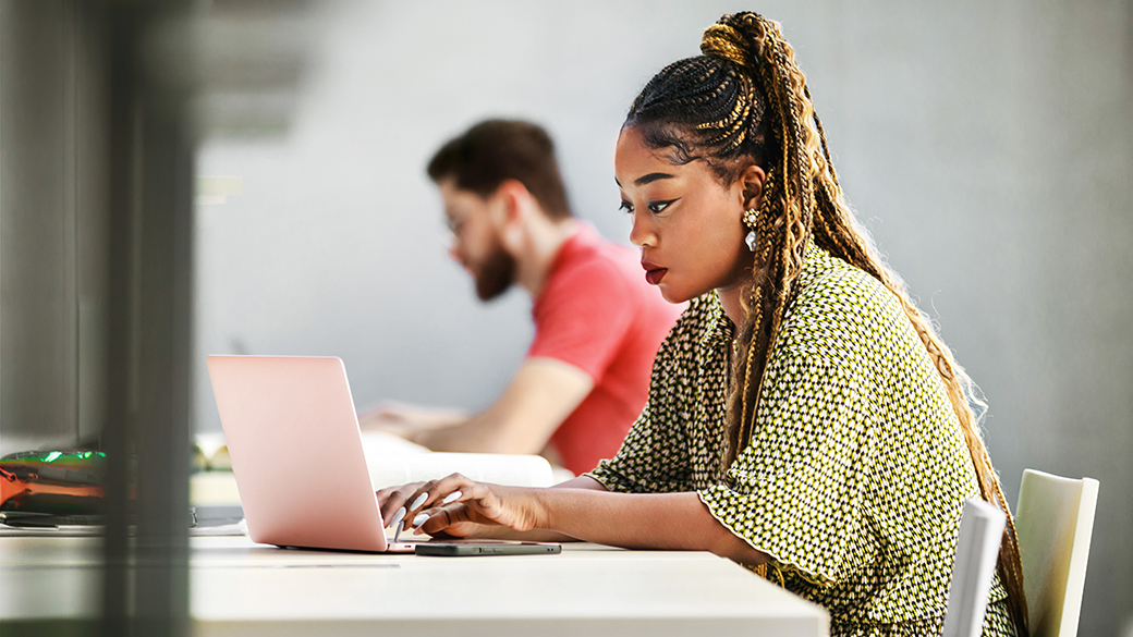 Coaching Leaders with the Tools to Influence Results 1 Focused Female Student Working on Laptop in Modern Library