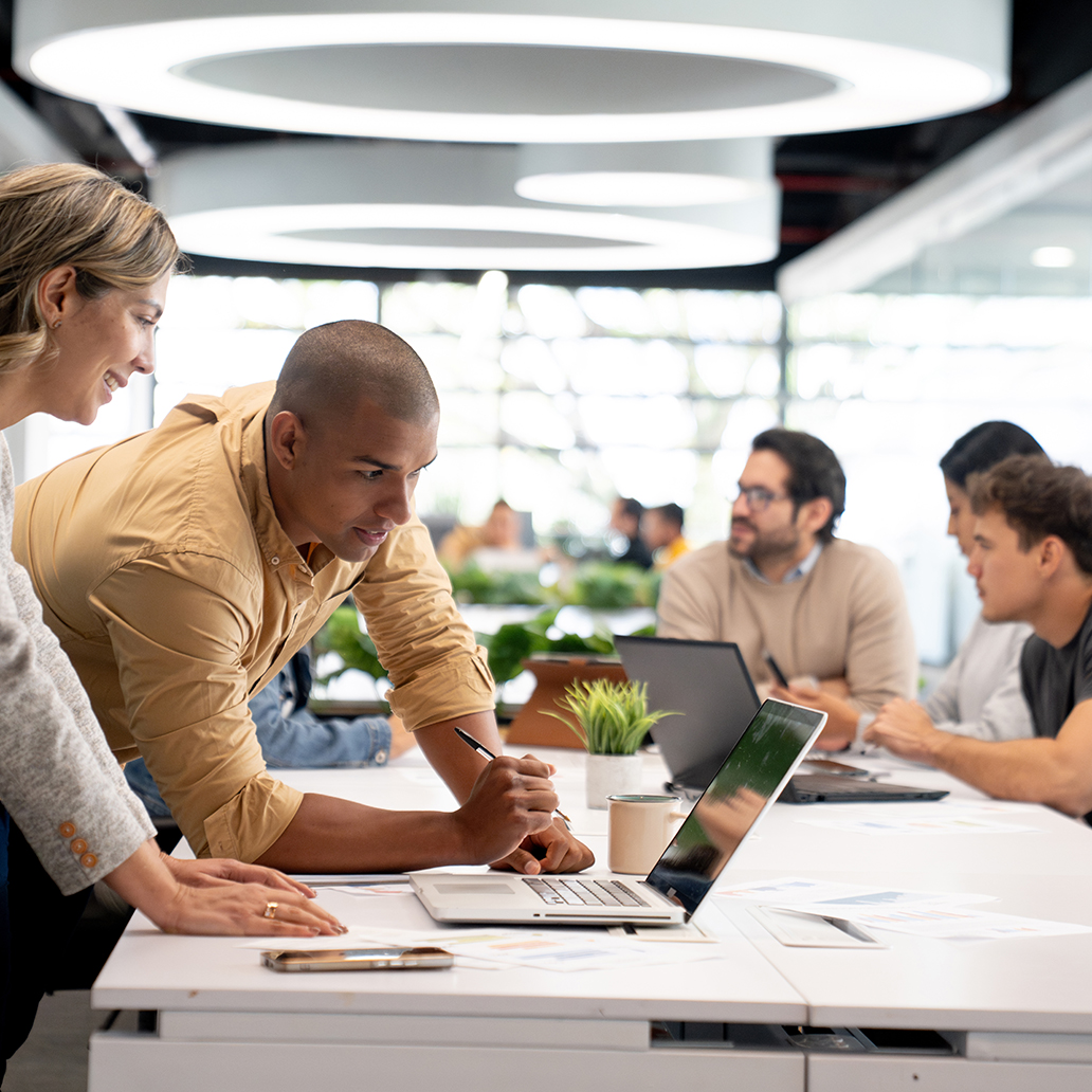 Team of coworkers at the office looking at a project on a laptop